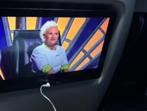 Anne Burrell Instagram - Ok… so this is a first… watching myself last night on #houseofknives while on a flight to Vegas!!! I was eating airplane snacks, knitting and watching like a crazy lady!! I think I look pretty good up there on the throne!!! Thank you to Nikol the lovely flight attendant who took the photo. 😊#ilovewhatido #luckygirl