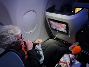 Anne Burrell Instagram - Ok… so this is a first… watching myself last night on #houseofknives while on a flight to Vegas!!! I was eating airplane snacks, knitting and watching like a crazy lady!! I think I look pretty good up there on the throne!!! Thank you to Nikol the lovely flight attendant who took the photo. 😊#ilovewhatido #luckygirl