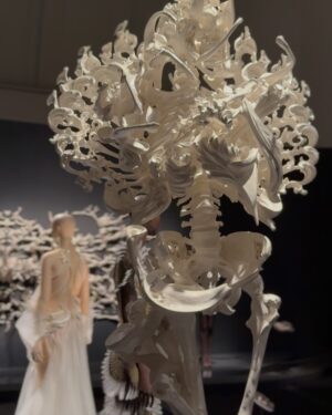 Fiona Xie Instagram - The Alchemy of @irisvanherpen @voguesingapore 

“I find beauty in the continual shaping of chaos which embodies the primordial power of nature’s performance,” Iris van Herpen once said—words that illuminated my understanding of her work at the nexus of ancient alchemy and @cern physics.

Her liminality is her genius. “I see technology as a tool to express the handwork better,” she explains, dissolving false binaries. When her kinetic structures breathe with the wearer, we witness her core philosophy: “Movement is my constant inspiration. Our human body is in continuous motion, as is everything around us.”

These undulating architectures manifest what philosopher Merleau-Ponty called “the flesh of the world”—the profound interconnectedness between perceiver and perceived. Her approach transforms rigid materials into liquid motion, embodying Bachelard’s insight that “matter is the unconsciousness of form.”

I remember showing my friend @grimes in that “Dune of Souls” creation at the met gala whispering “It would be a dream to wear these.” Then @voguesingapore @nat_tasha ‘s call came—Iris would dress me for the @artsciencemuseumsg retrospective. I swooned like a teenager locked lips in her first kiss. Manifestation is real. 

“Fashion is an expression of the zeitgeist, while couture is an expression of eternal beauty.” These words resonated as I stood transfixed clad in her “Architectonics” collection—embodying what Rilke meant by “living the questions” about our relationship with technology, philosophy, architecture, music, nature, and our bodies.

Draped in her vision, I understood: Iris van Herpen doesn’t design clothing. She designs portals to possibility itself.​​​​​​​​​​​​​​​​

Be transcended at @artsciencemuseumsg 
#IrisVanHerpen #ArtAndFashion #Metamorphosis​​​​​​​​​​​​​​​​ #Vogue
